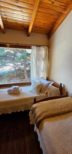 a bedroom with two beds and a window at Casa Pier Giorgio in El Chalten