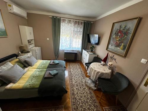 a small room with a bed and a table at RELAX13 Vendégház in Hévíz