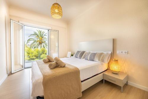 a bedroom with a large bed and a large window at Mar Blau in Port d'Alcudia