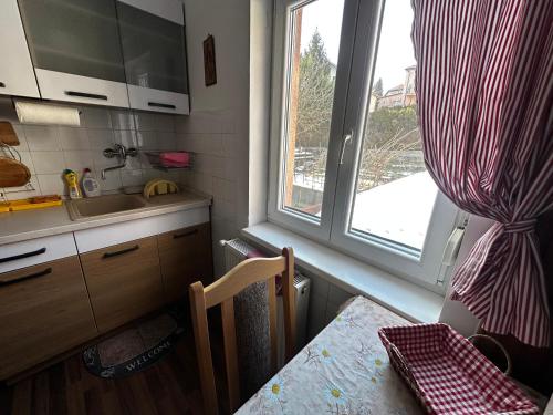 a kitchen with a window and a table and a sink at RELAX13 Vendégház in Hévíz