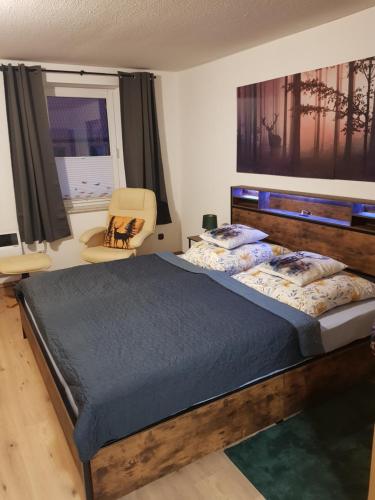 a bedroom with a large bed and a chair at Haus Flora in Hasselfelde
