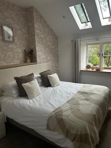 a bedroom with a large white bed with pillows at The Stable at Woodhouse Farm in Montacute