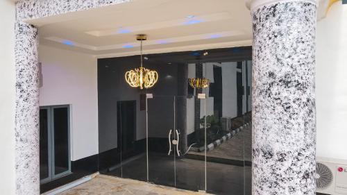 a lobby with a glass door and a chandelier at Royal Modak Resort & Hotel in Ibadan
