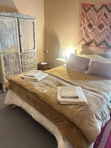 a bedroom with a large bed and a dresser at Refugio Caro Cox in Tilcara
