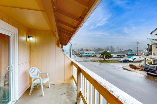 a chair sitting on a balcony with a view of a street at Sea Treasures Inn #206 in Rockaway Beach