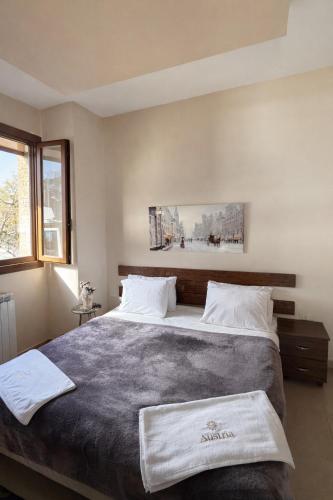 a bedroom with a large bed with two towels on it at Austria Luxury Apartments, Faraya Hotel in Fārayyā