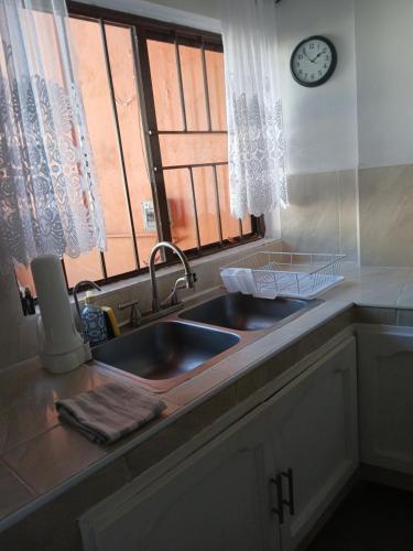 eine Küchentheke mit Spüle und Fenster in der Unterkunft Casa Solares in Atlixco
