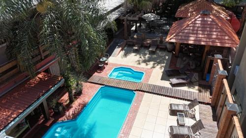 an overhead view of a pool with chairs and a house at Pousada Sonho Meu Foz in Foz do Iguaçu