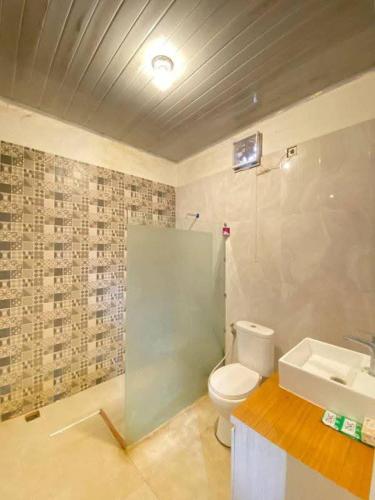 a bathroom with a toilet and a sink at Hotel Raudah Kapuas in Kualakapuas