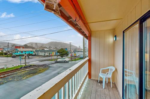 a balcony with a chair and a view of a street at Sea Treasures Inn #208 in Rockaway Beach