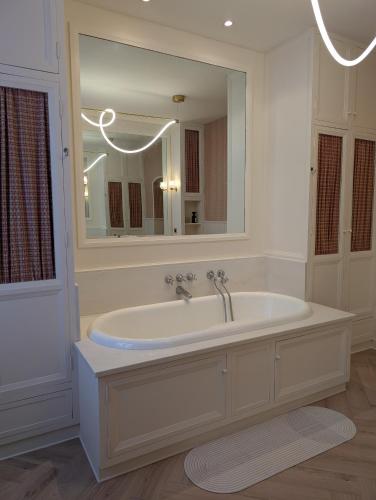 a bathroom with a tub and a large mirror at Château du Mas de l'Âge in Couzeix