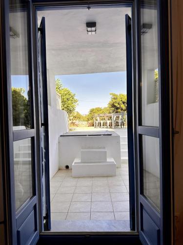 an open door to a patio with a bench outside at Sea View Cycladic Home in Santa Maria