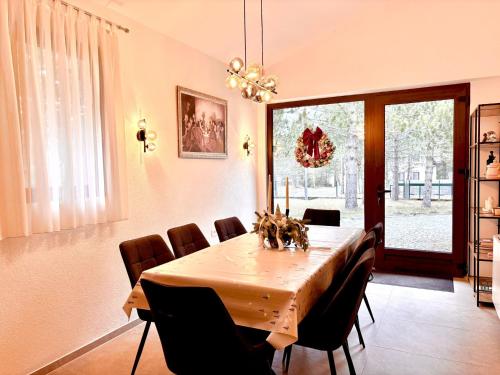a dining room with a wooden table and chairs at Calm Stay Blidinje in Blidinje