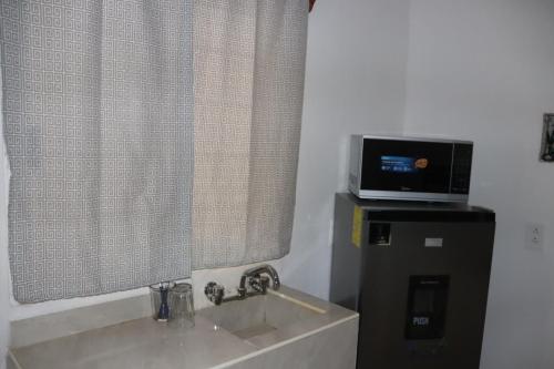 a bathroom with a sink and a television at Habitaciones Aurelia in Felipe Carrillo Puerto