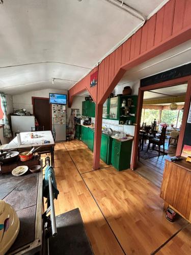 a kitchen with green cabinets and a wooden floor at Casona de Campo in Puerto Varas