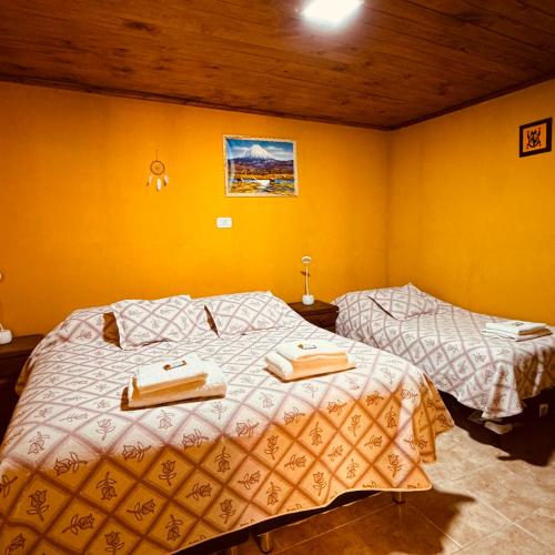 una camera da letto con due letti con asciugamani sopra di Sumaq Samay a San Antonio de los Cobres