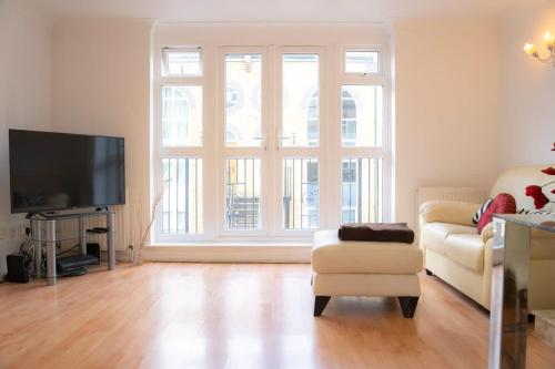 a living room with a couch and a television at Stylish 3-Bed Lambeth Apartment Moments from Westminster & Brixton in London