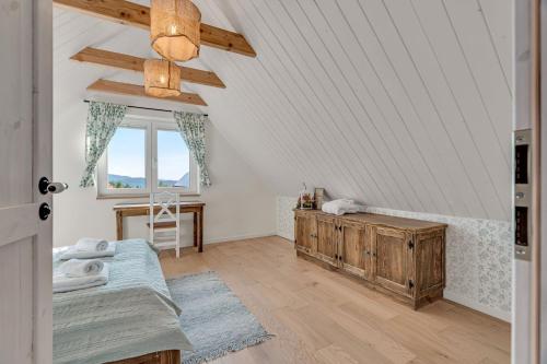a attic room with a bed and a window at U Pana Boga za piecem - domki w górach, Sauna, Beskidy, Koszarawa in Korbielów