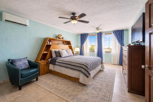 a bedroom with a bed and a fan and a chair at Penthouse Water View in Puerto Peñasco