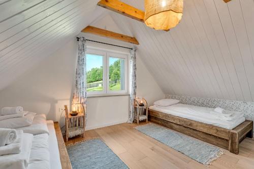 a attic room with two beds and a window at U Pana Boga za piecem - domki w górach, Sauna, Beskidy, Koszarawa in Korbielów