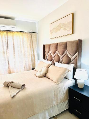 a bedroom with a large bed with a large headboard at Habitat Kappa Alexio in Gaborone