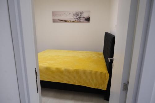 a bedroom with a yellow bed in a white room at Luxury Villa JAKOV in Banja Luka