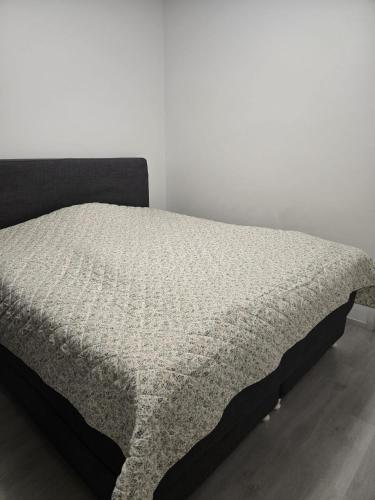 a bed in a room with a white wall at Metsämansikan helmi I Free parking & Netflix I 5G in Espoo