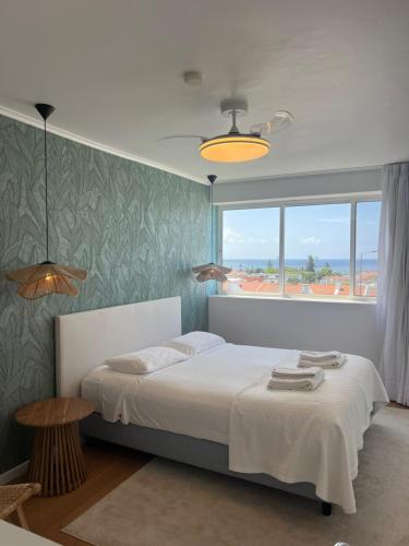 a bedroom with a bed and a large window at Toi et Moi Apartments-Guests speek for us! in Ponta Delgada