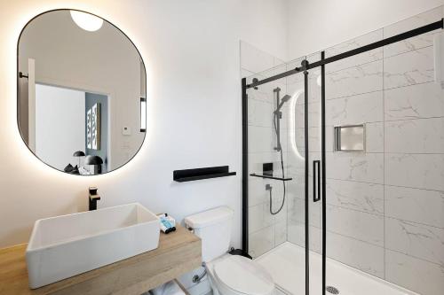 a bathroom with a toilet and a sink and a mirror at Chalet Peak Tremblant: Your Mountain Escape. in La Conception