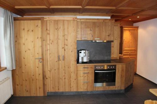 a kitchen with wooden cabinets and a microwave at Haus Martina Buchhammer in Fendels