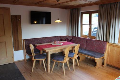 a dining room with a table and chairs and a couch at Haus Martina Buchhammer in Fendels