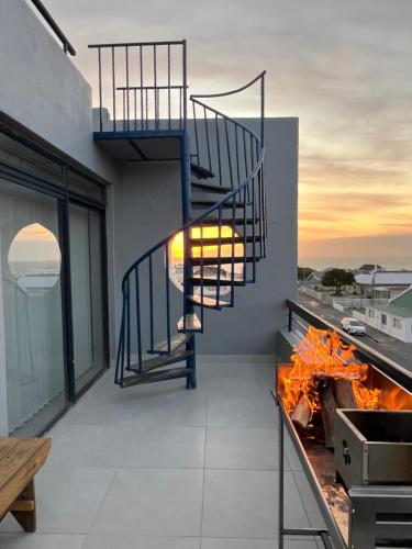 a spiral staircase on a balcony with a fire at SaltySky Penthouse in Gansbaai