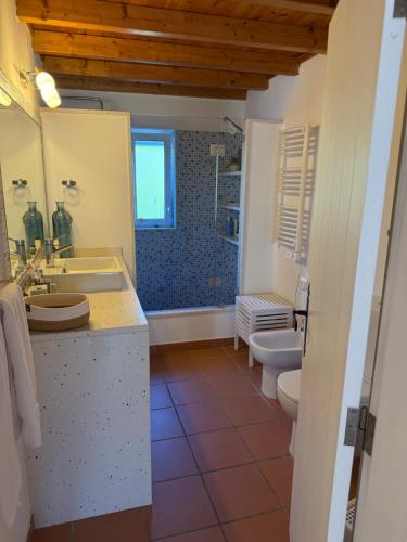 a bathroom with two toilets and a sink and a tub at Vila Brisa do Mar in Comporta