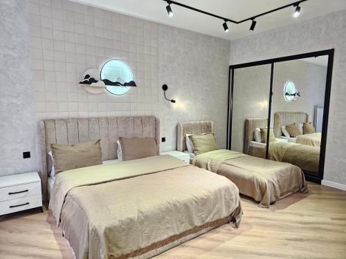 sypialnia z dwoma łóżkami i lustrem w obiekcie Villa Wolverine w mieście Qəbələ