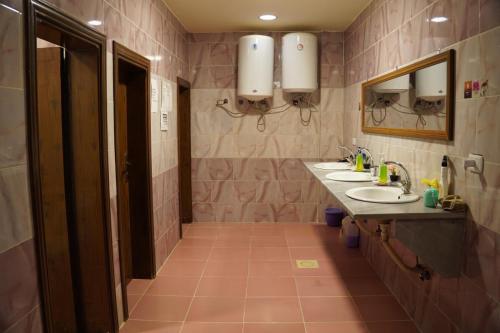 a bathroom with two sinks and two mirrors at Petra voyager Hostel in Wadi Musa