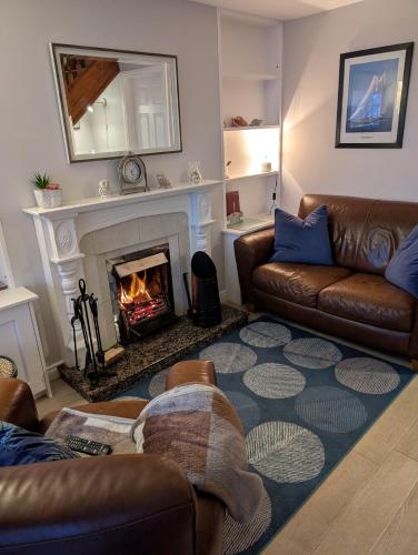 a living room with a couch and a fireplace at Widows Row Cottage in Newcastle