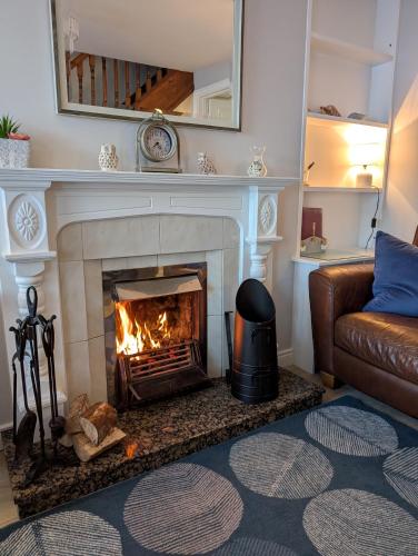 a living room with a fireplace and a couch at Widows Row Cottage in Newcastle