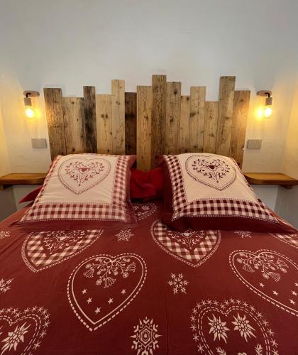 a bedroom with two beds and a wooden headboard at La Petite Marguerite in Bionaz