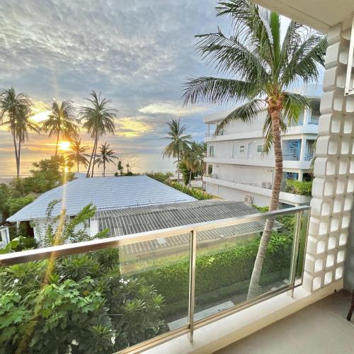 a balcony with a view of a building and a palm tree at Stardust Boutique Hotel in Hua Hin