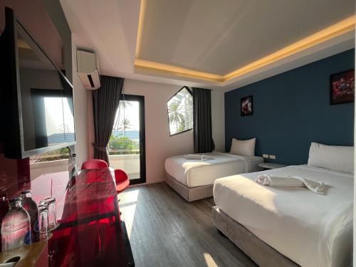 a hotel room with two beds and a television at Stardust Boutique Hotel in Hua Hin