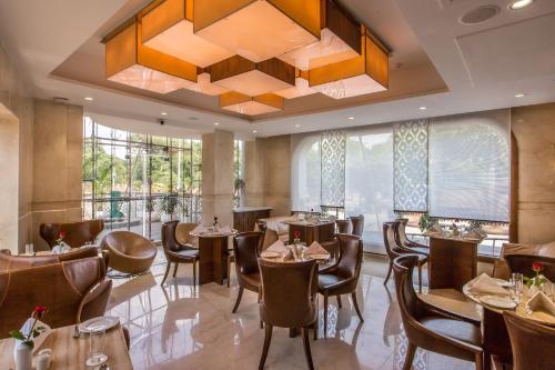 a restaurant with tables and chairs and a chandelier at Clarks Inn Suites Gwalior in Gwalior