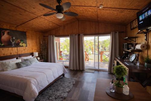 a bedroom with a bed and a ceiling fan at Paraíso del Valle in Ensenada