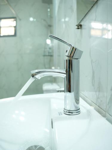 a bathroom sink with a faucet and aaucet at SUITE De PARIS in Abuja