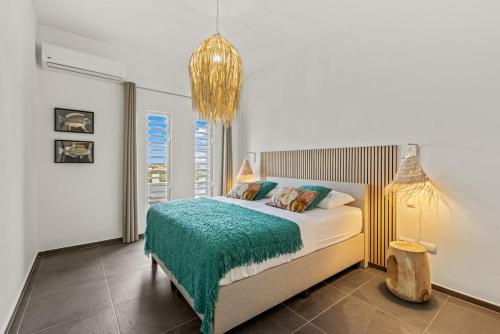 una camera da letto con un letto con una coperta verde e un lampadario a braccio di Casa Koba a Grote Berg