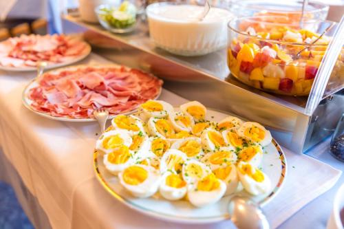 un buffet con huevos y jamón en una mesa en Garni - Hotel Rinner Julia, en Laces
