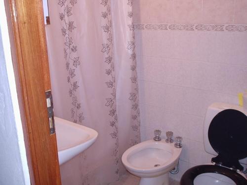 a small bathroom with a toilet and a sink at Hostal Sur in Villa Gesell