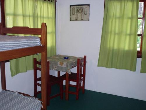 a small table and chairs in a room with a bunk bed at Hostal Sur in Villa Gesell