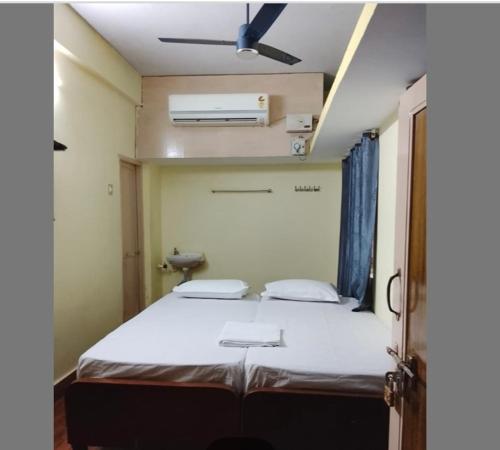a bedroom with a large bed with a ceiling fan at JB lodge in Chidambaram