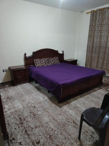 a bedroom with a purple bed and a chair at الشقة العائلية الحديثة familial new flat in Amman