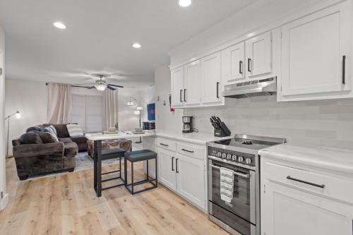 a kitchen with white cabinets and a table and a couch at The Tanglewood Upper Suite in Chattanooga